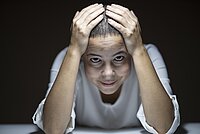Frau mit Händen am Kopf
