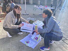 Zwei Frauen mit gemalten Pappschildern zu Demokratie