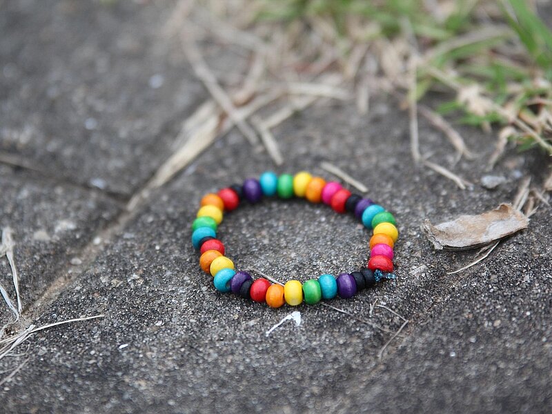 Bunte Perlenkette liegt auf der Straße.