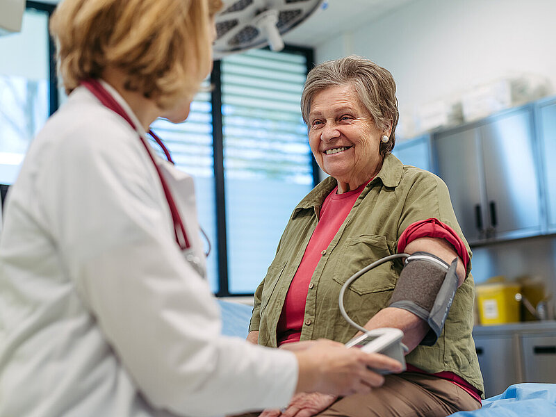 Zwei Frauen; eine Ärztin misst Blutdruck