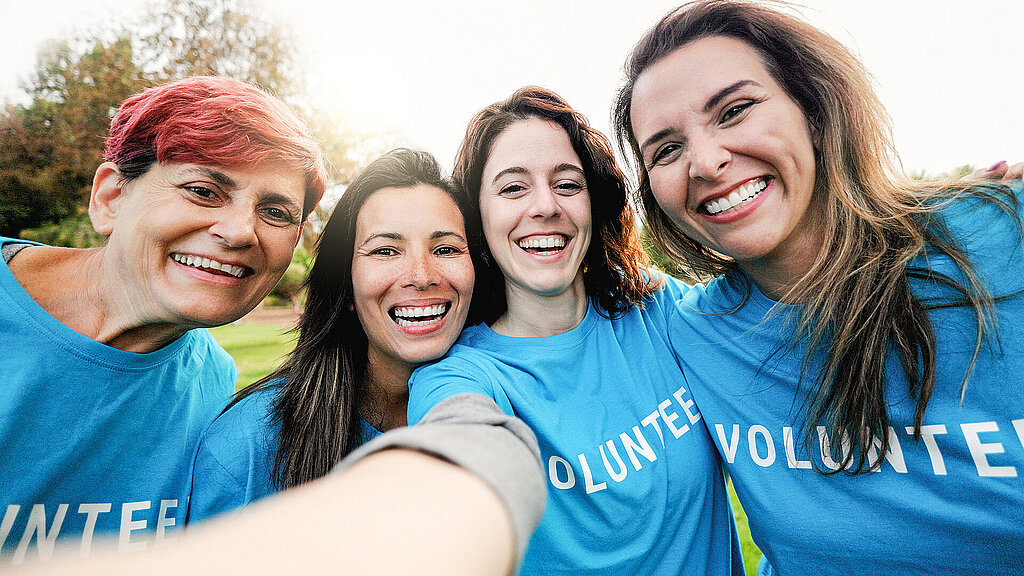 Happy group of volunteer people taking selfie